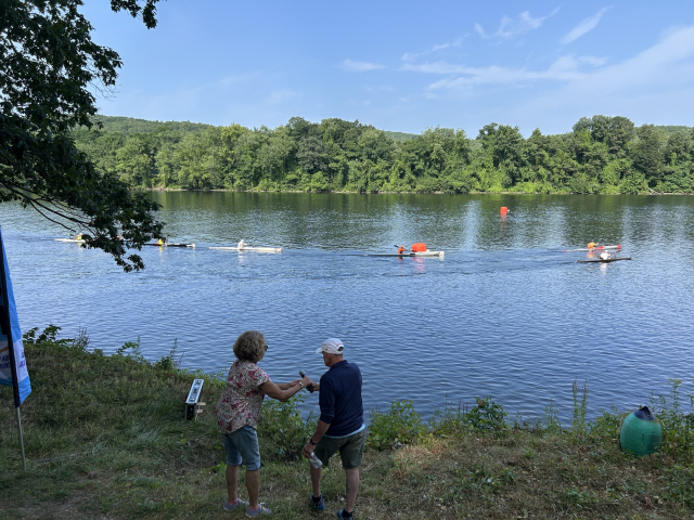 Race directors Peter and Trish Heed watch paddlers pass by the start/finish on their way upstream